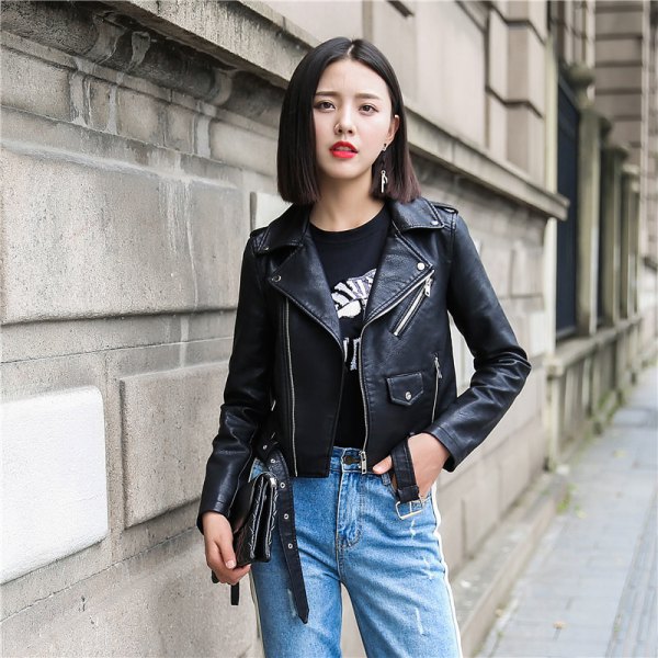 Black cropped leather jacket with a printed t-shirt and blue slim-fit jeans