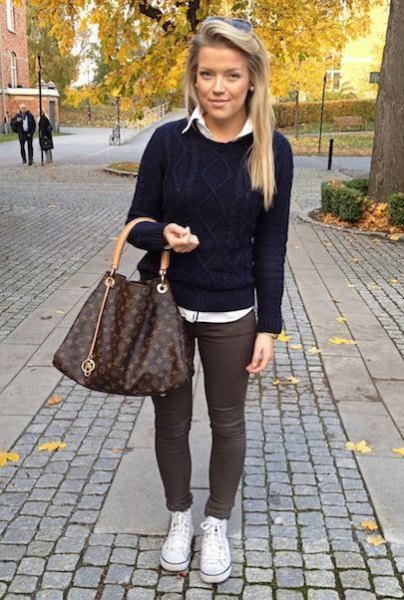 Black cable knit sweater with white shirt and gray skinny trousers