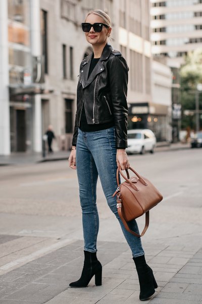 Black leather motorcycle jacket with grey-blue skinny jeans and heeled boots