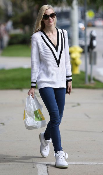White and black ribbed v-neck sweater and navy skinny jeans