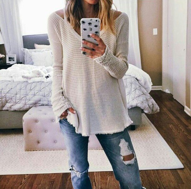 White ripped V-neck boatneck sweater paired with boyfriend jeans