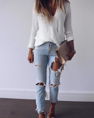 White ribbed v-neck oversized sweater and blue ripped slim fit jeans