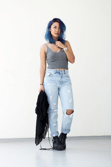 gray tank top with light blue ripped mom jeans and leather
boots