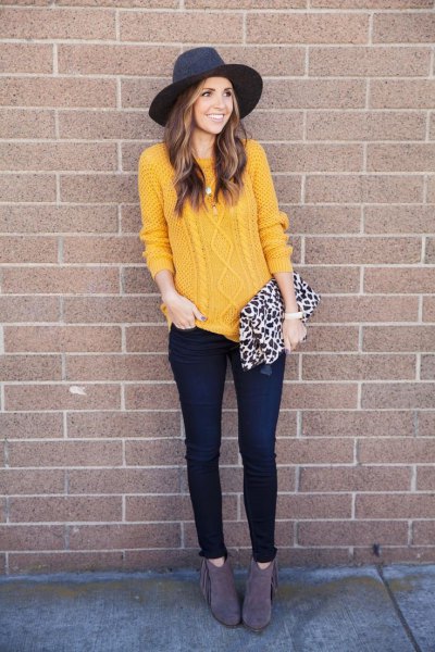 Cable-knit sweater with a black felt hat and skinny jeans