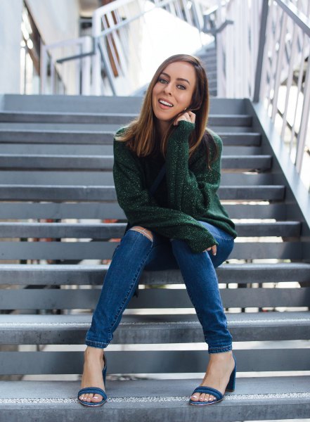 Team a green chunky knit sweater with blue skinny jeans with ripped knees