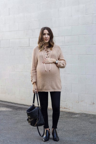 Tan oversized sweater with black cuffed jeans and leather boots