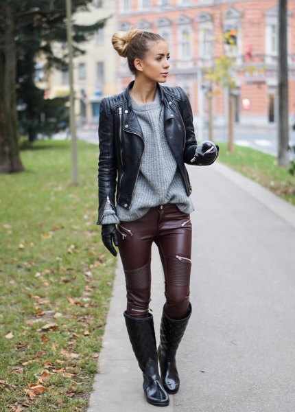Black biker jacket with a gray chunky ribbed sweater and leather leggings