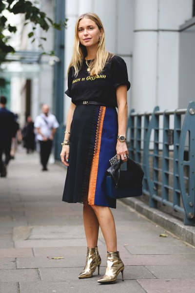 Black graphic t-shirt with a high-rise midi skirt and gold ankle boots