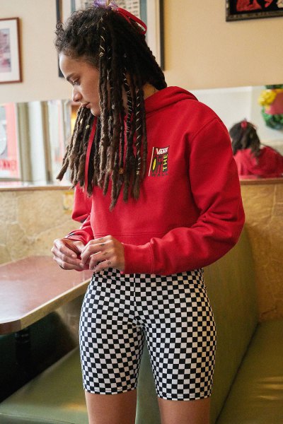 Red graphic hoodie with black and white checkered biker shorts