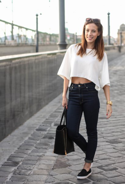 White sweater with wide sleeves and black cuffed jeans