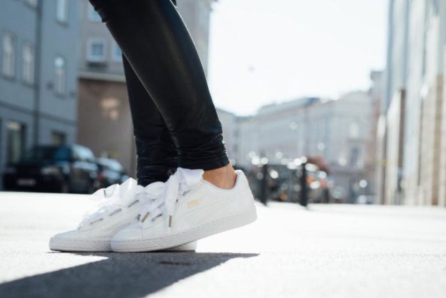 Black leather leggings with white low-top walking sneakers