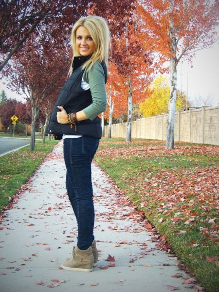 black quilted vest with dark blue skinny jeans and suede boots