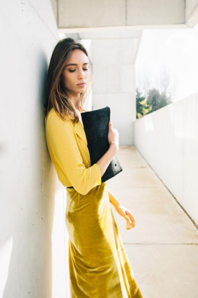 yellow ribbed sweater with mustard midi dress and black leather
clutch