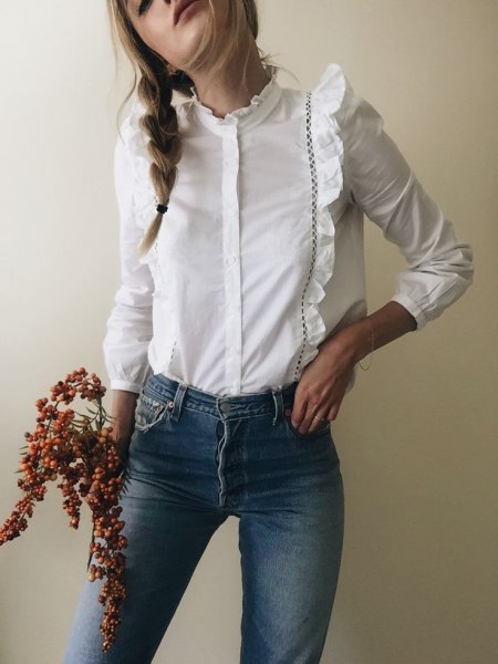White long sleeve ruffle shirt with buttons and blue skinny jeans
