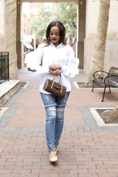 Pair a ruffle sleeve shirt with light blue ripped slim fit
jeans