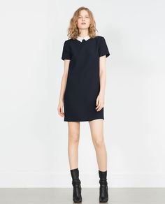 Black mini shift dress with mid-heeled leather boots
