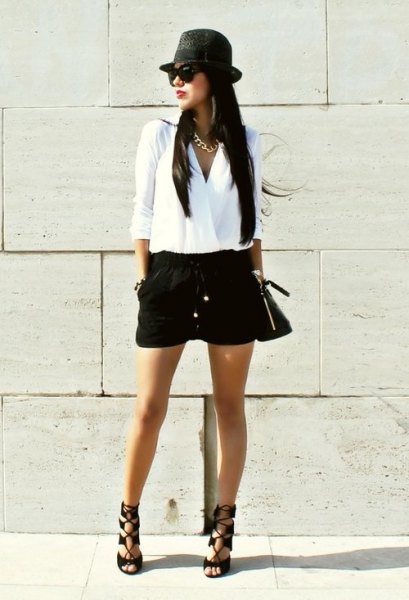 White wrap blouse with black mini shorts and flat hat