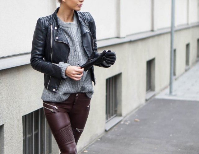black leather jacket with gray ripped sweater and motorcycle trousers