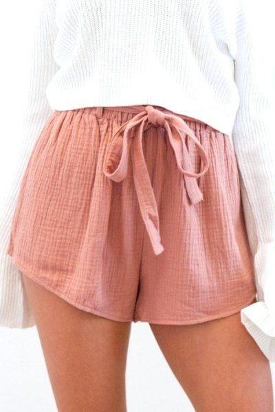 White ribbed knit oversized jumper paired with pink mini chiffon shorts with elastic waistband to tie at front