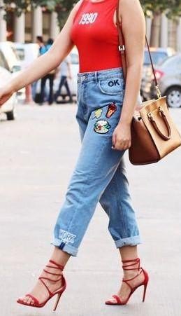 red sleeveless t-shirt with blue embroidered boyfriend jeans