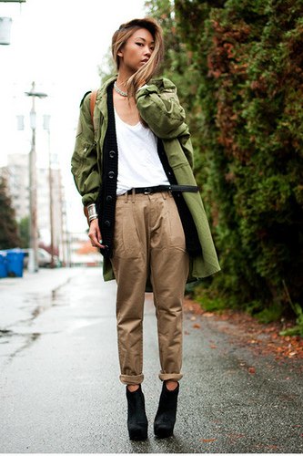 Green long military jacket with white tank top and cuffed chinos
