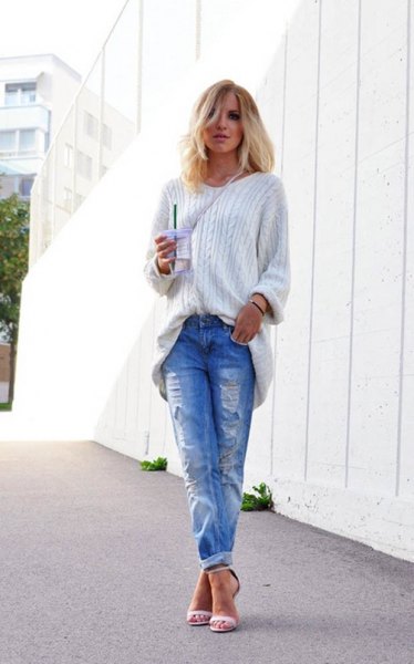 White cable knit chunky sweater and blue ripped cuffed jeans