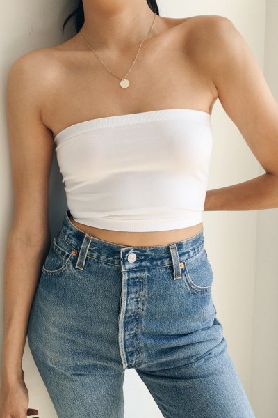 White cropped strapless top paired with blue high-rise skinny jeans