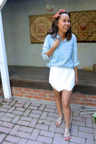 Light blue shirt with buttons and white mini fold-over skirt