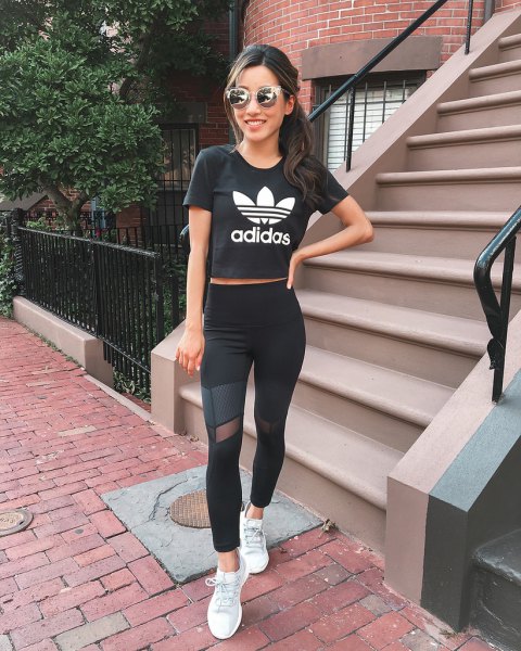 Black cropped graphic t-shirt with mesh leggings and white sneakers