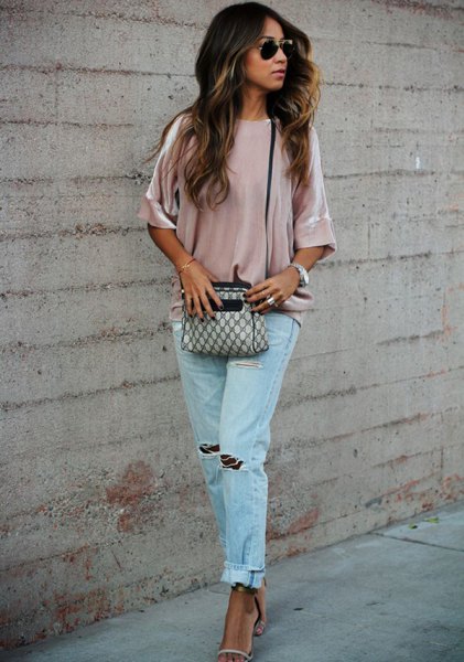 Pink velvet shirt with wide sleeves and blue ripped boyfriend jeans