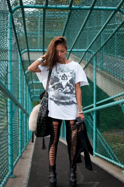 White oversized graphic t-shirt with black leggings and boots