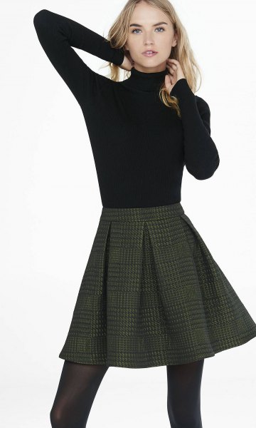 Black, waisted sweater with stand-up collar and dark red checked mini skirt