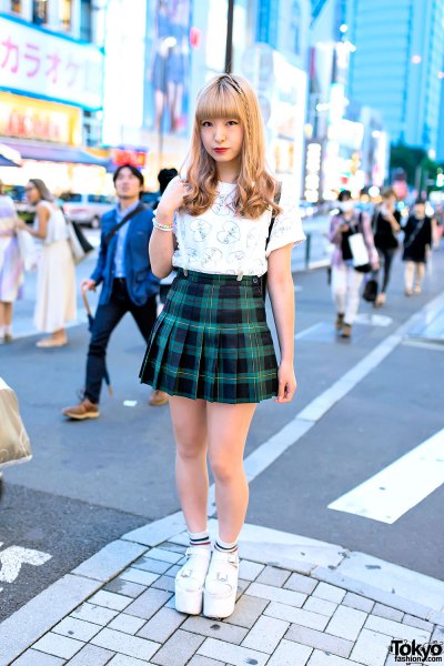 White graphic tee with green and black check pleated mini skirt