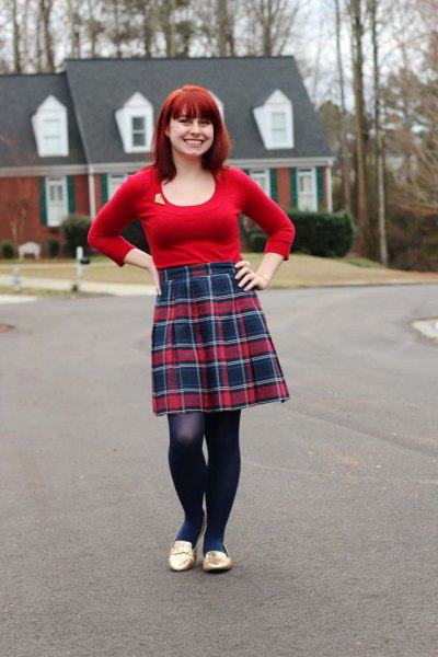 Red fitted long sleeve t-shirt with a scoop neckline and knee
length pleated skirt