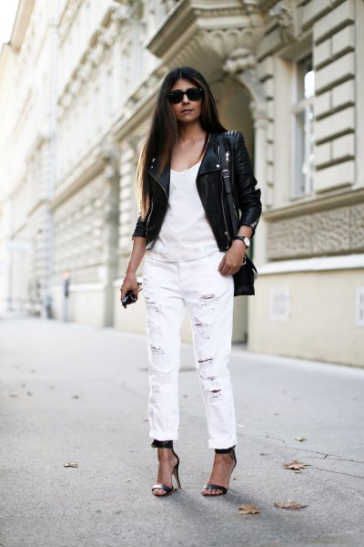 Black leather motorcycle jacket with white tank top and cuffed straight leg jeans