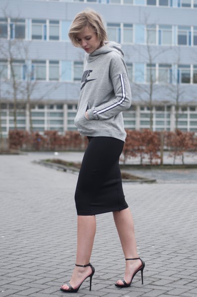 Gray hoodie with a black mini skirt and open heels