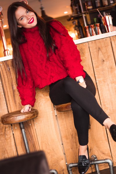 Red cable-knit turtleneck sweater and black slim-fit jeans
