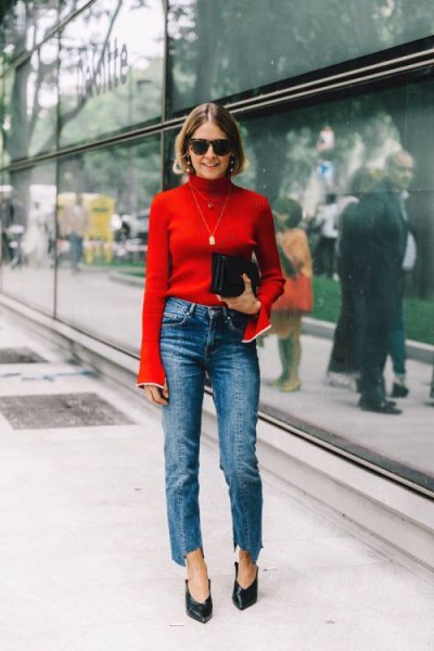 Red bell sleeve turtleneck and blue cropped straight leg jeans