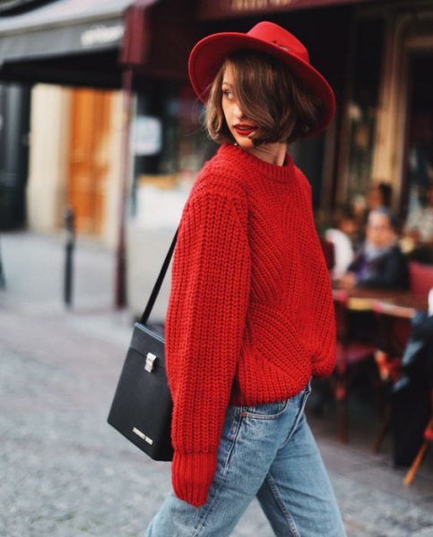 Red felt hat with a thick red sweater and light blue jeans