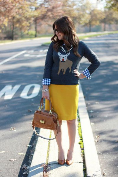 Gray sweater with Christmas graphic, plaid shirt and yellow
skirt