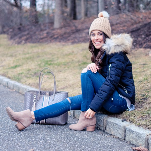 Black down jacket with blue skinny jeans and crepe knit hat