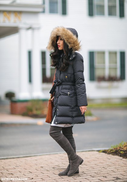 Black long down jacket with fur hood and white tunic dress