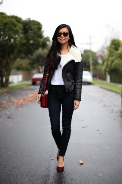 Black flight jacket with a white fur collar and skinny jeans