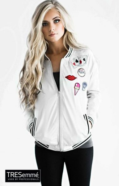 White embroidered bomber jacket with black tank top and skinny jeans