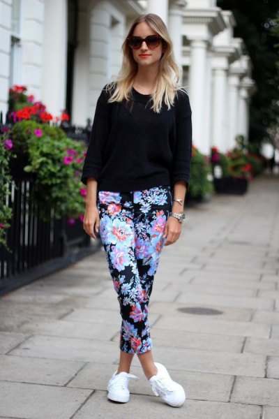 Black three-quarter sleeve sweater, blue floral shorts and white sneakers