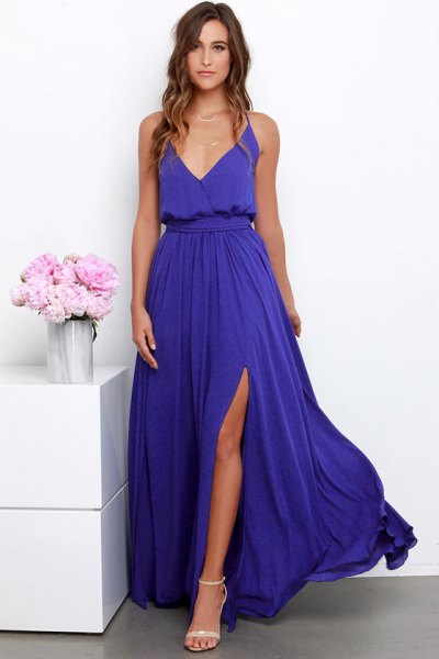 Long, purple, flowy dress with a deep V-neckline, a gathered waist,
and a high slit