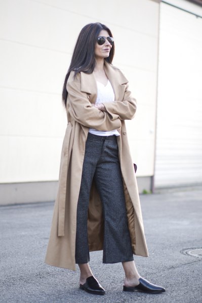 Long, soft pink belted trench coat with gray flared chinos and loafers