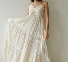 White maxi pleated dress with spaghetti straps and a flared cut