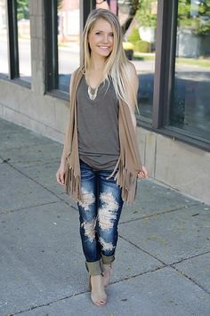 Sleeveless fringed cardigan and ripped boyfriend jeans
