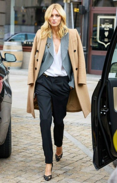 Light, camel-colored long wool coat with black suit trousers